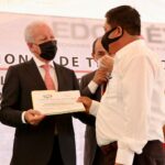 Jorge Rescala Pérez, Secretario del Medio Ambiente, entyrtega su nombramiento a uno de los delegados electos de Tejupilco, en la ceremonia de aniversario del municipio.