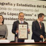 Fernando Flores, Alcalde de Metepec, muestra el Pergamino al Mérito Presidente Adolfo López Mateos, que le entregó la SOMEGEM